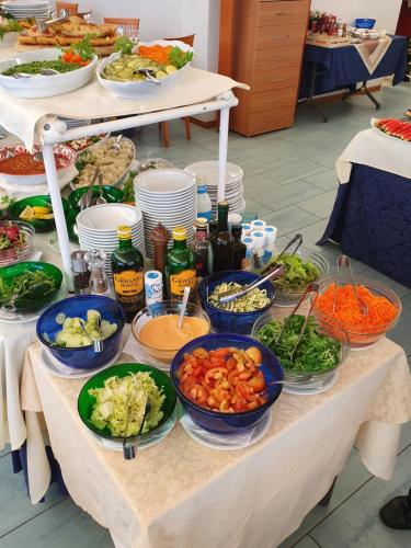 a table with bowls of vegetables and other foods at Hotel Margareth in Riccione
