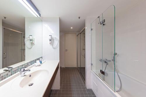a bathroom with a sink and a shower at Radisson Blu Hotel Lietuva in Vilnius