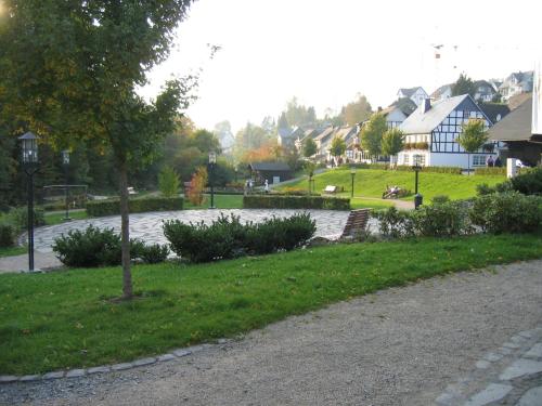 a park with houses and a street light and grass at Pension & Ferienhaus Latröpchen in Schmallenberg