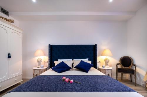 a bedroom with a large bed with blue pillows and flowers on it at Lux Apartments Barcelona in Barcelona