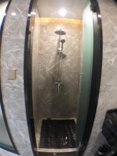 a shower in a bathroom with a mirror at Le Chen Miiya Hotel in Sihanoukville
