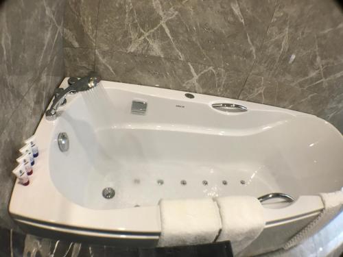 a white bath tub in a bathroom with a towel at Le Chen Miiya Hotel in Sihanoukville