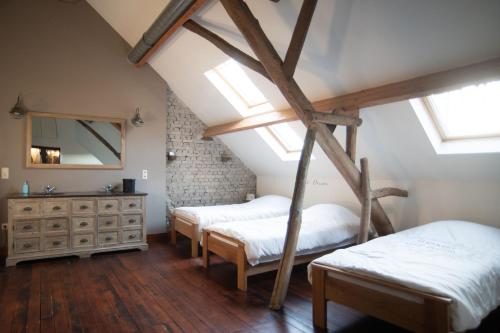 1 dormitorio en el ático con 2 camas y espejo en Villa Vigor, en Peer
