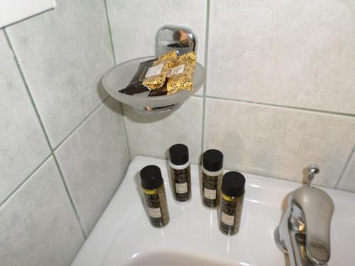 a bathroom sink with three bottles of spices on it at Asfodelos Apartment Hotel in Kakovatos