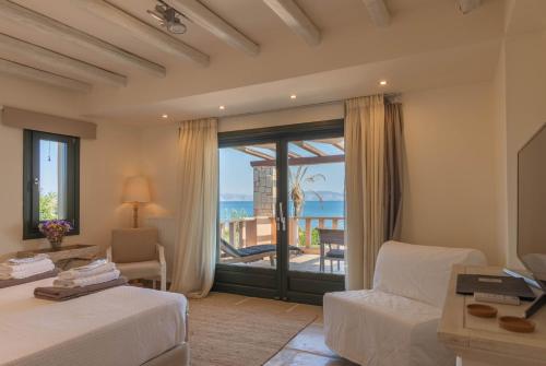 a bedroom with a bed and a view of the ocean at Therme Sea Luxury Lodge in Thermisia