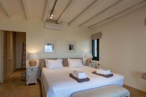 a bedroom with a large white bed in a room at Therme Sea Luxury Lodge in Thermisia