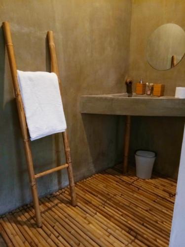 a bathroom with a chair and a sink with a mirror at Vanpila in Savannakhet