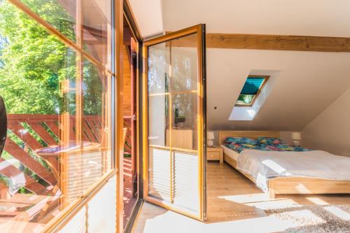a bedroom with a bed and a sliding glass door at Komfortowy Leśny Dwór in Sztutowo