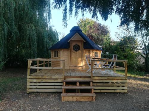 a small wooden play house with a blue roof at Camping Loisirs Des Groux in Mousseaux-sur-Seine