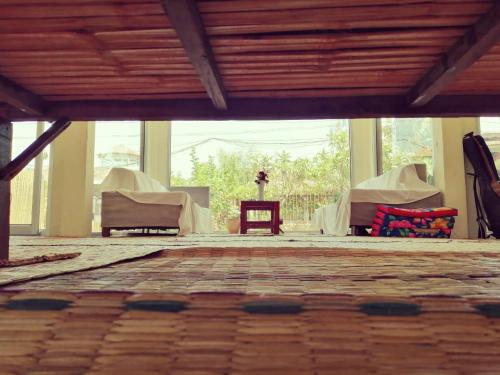une chambre avec des tables et des chaises dans un bâtiment dans l'établissement Vanpila, à Savannakhet