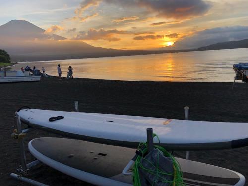 a pair of surfboards on the beach at sunset at Vegetarian House Jamoo in Yamanakako