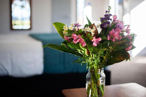 a glass vase filled with flowers on a table at Carrick Lodge Motel in Cromwell