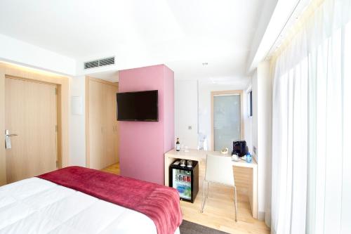 a bedroom with a pink wall with a sink at Sercotel Ciudad de Miranda in Miranda de Ebro