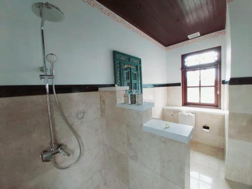 a bathroom with a shower and a sink at Villa Tanah Carik by Mahaputra in Tegalalang