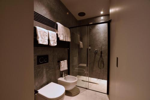 a bathroom with a shower and a toilet and a sink at Boutique Hotel de la Ville in Laigueglia