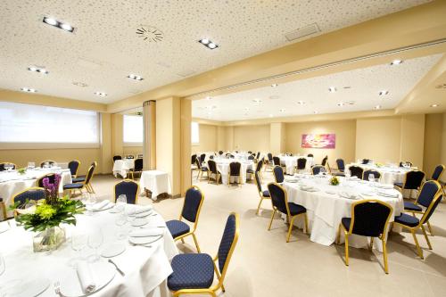 a conference room with white tables and chairs at Sercotel Ciudad de Miranda in Miranda de Ebro