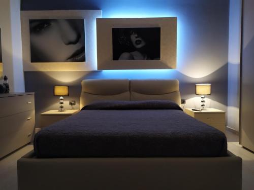 ein Schlafzimmer mit einem Bett und zwei Bildern an der Wand in der Unterkunft B&B Crocco D'Oro in Caltavuturo
