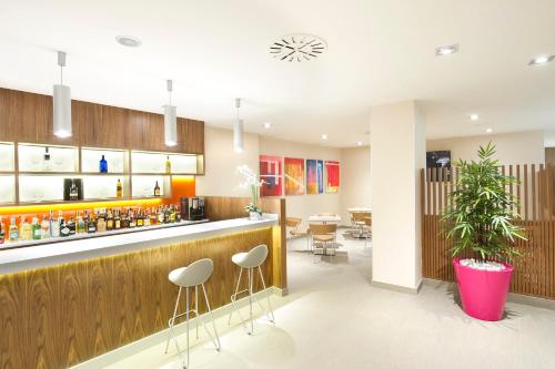 a bar in a restaurant with stools at Sercotel Ciudad de Miranda in Miranda de Ebro