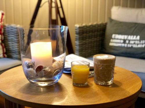 a candle and two glasses of orange juice on a table at Hotell Uddewalla in Uddevalla