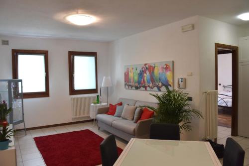 uma sala de estar com um sofá e um tapete vermelho em Appartamento CA TIZIANA 2 "Wonderful" di Tiziana - Venezia - Jesolo beach em Musile di Piave