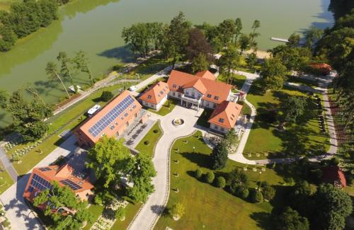 an aerial view of a house with a lake at Leśny Dwór in Sulęczyno