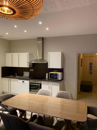 eine Küche mit einem Holztisch und Stühlen in der Unterkunft Appartement de 95 m2 bien situé in Boulogne-sur-Mer