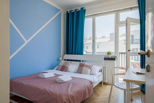 Schlafzimmer mit einem Bett mit blauen Wänden und einem Schreibtisch in der Unterkunft Apartments Stepanska 36 in Prag