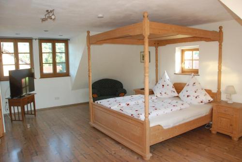 a bedroom with a wooden canopy bed with pillows at Ferienwohnung Christina in Vaihingen an der Enz