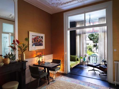 a living room with a table and chairs and a large window at City B&B Villa Nicola in Amsterdam