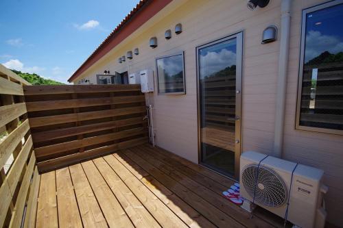 a large wooden deck next to a house at Alezed Villa Shiraho in Ishigaki Island