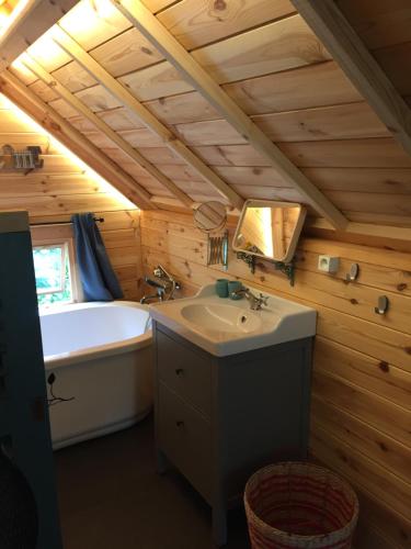 a bathroom with a tub and a sink and a bath tub at La cabane de l'Atelier in Bomal