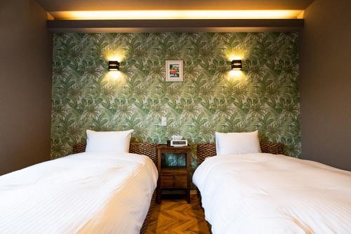 dos camas sentadas una al lado de la otra en una habitación en Alezed Villa Shiraho, en Ishigaki Island