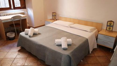 1 dormitorio con 1 cama con 2 toallas en HostelCiompi en Siena