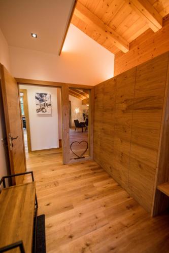 a room with wooden flooring and a room with a piano at Leni´s Appartements in Fieberbrunn