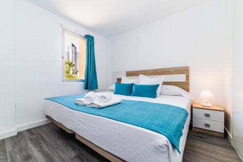 een slaapkamer met een groot bed en handdoeken bij Apartamentos Moby Dick by WT in Benidorm