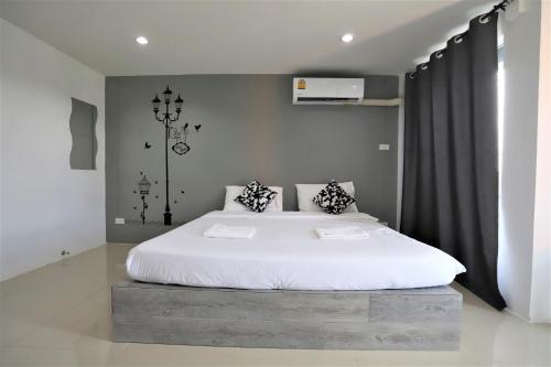 1 dormitorio con 1 cama grande con sábanas blancas en Rest Point Sampran, en Nakhon Pathom