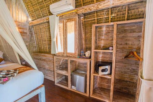 レンボンガン島にあるサンヒャン ベイ ヴィラズの木製の壁、ベッド、窓が備わる客室です。