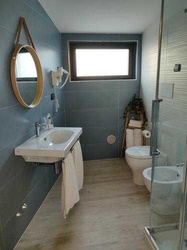 ein Badezimmer mit einem Waschbecken, einem WC und einem Spiegel in der Unterkunft Dimora Dei Cento in Pescara