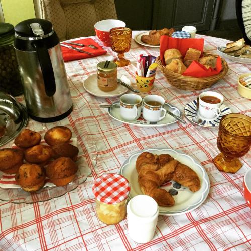 a table topped with plates of pastries and bread at Chez Les Brocs B&B in Canet d'Aude