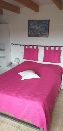 - une chambre avec un lit rose et des oreillers rouges dans l'établissement Chambre du Raisin, à Puyricard