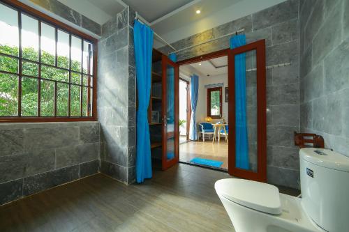 a bathroom with a shower and a toilet in a room at Hoi An Sea Village Homestay in Hoi An