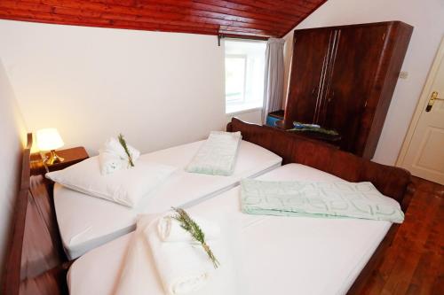 two beds in a room with white sheets and pillows at Apartment Dulcis in Stari Grad