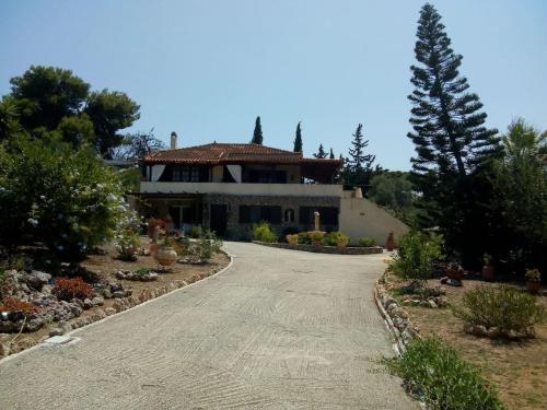 une allée menant à une maison avec un arbre dans l'établissement Villa Rita - Porto Heli, à Porto Heli