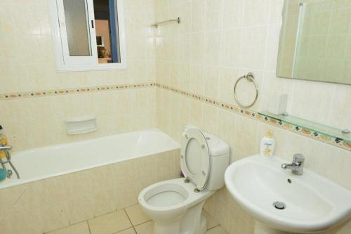 Un baño blanco con inodoro y lavabo. en Limnaria Villas Sunny Garden Apartment, en Pafos
