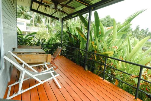 a deck with a chair and a bench on a porch at Saree Lagoon Villa Koh Samui in Lipa Noi