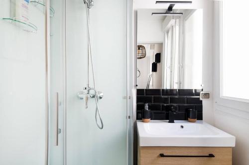 a bathroom with a white sink and a mirror at Le Temple de La Rochelle in La Rochelle