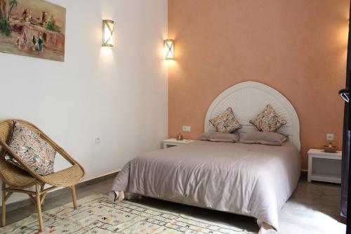 een slaapkamer met een bed en een stoel bij RIAD COME & VA Location Privatisée in Marrakesh