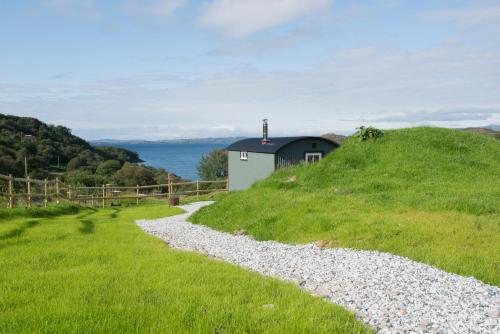 a gravel road leading to a small house on a hill at West Coast Hideaways in Nedd
