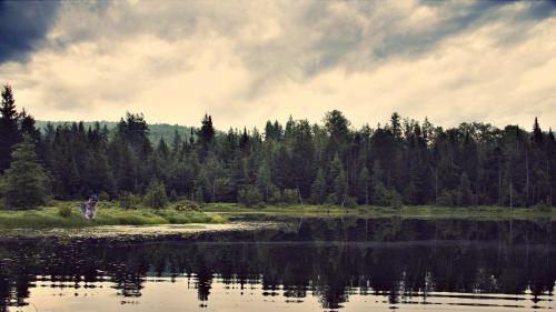 a person standing next to a body of water at Domaine Summum in Mont-Tremblant