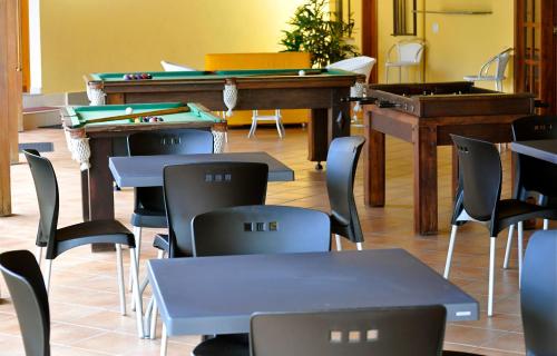 a classroom with tables and chairs and a piano at Porto Geraes Praia Hotel in Porto Seguro